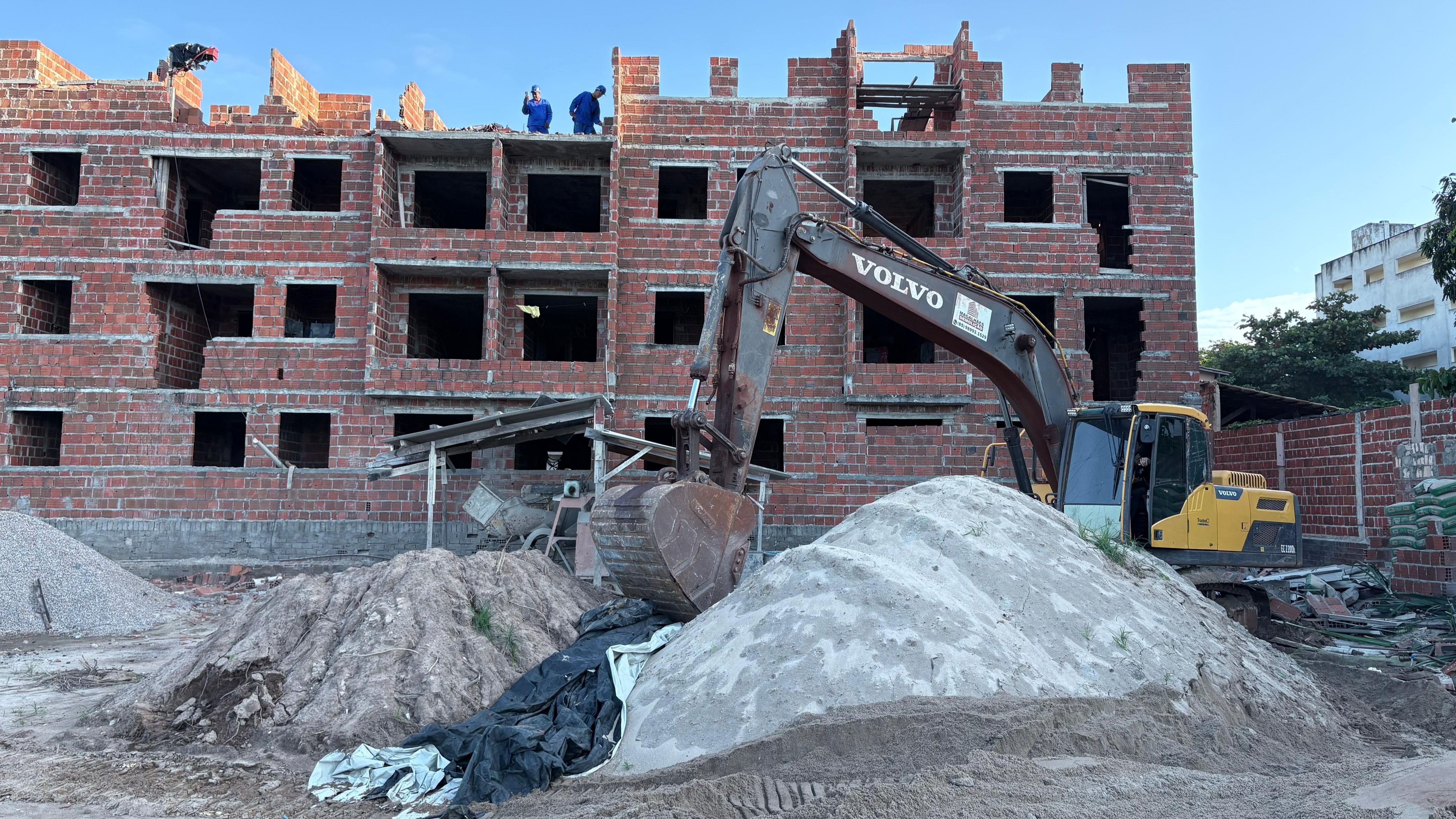 máquinas demolindo um prédio irregular